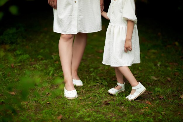 Mãe e filha em foto de roupas brancas da cintura para cima