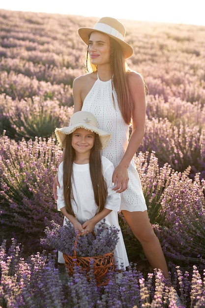 Mãe e filha em um campo de lavanda florescendo ao pôr do sol