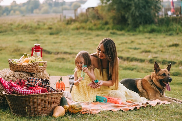 mãe e filha em um piquenique com um cachorro