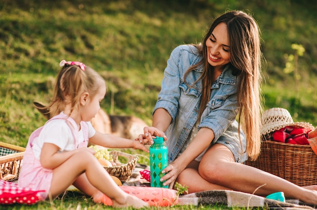 mãe e filha em um piquenique com um cachorro