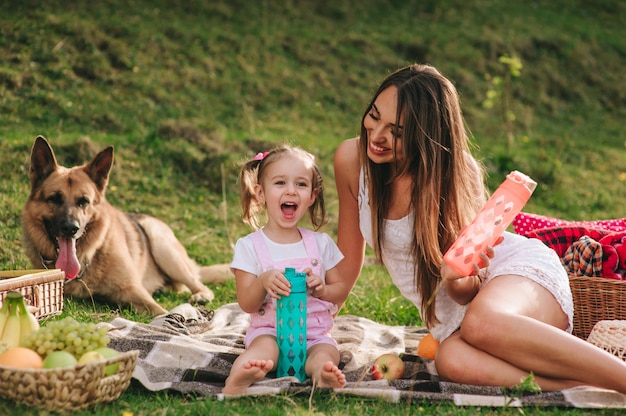 mãe e filha em um piquenique com um cachorro