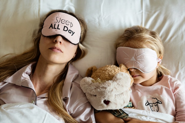 Mãe e filha em vendas dormindo na cama