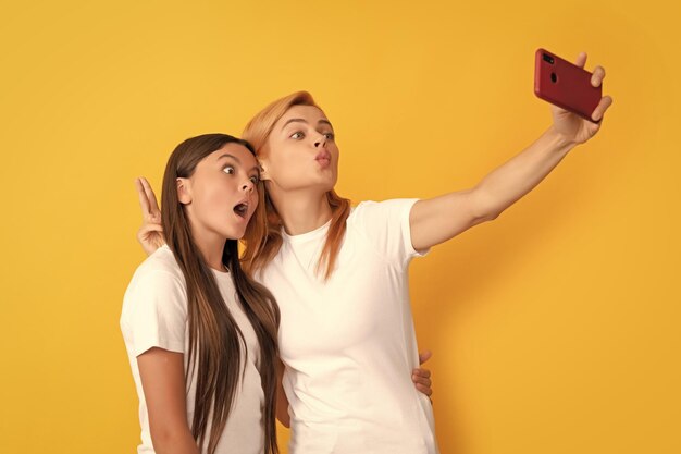 Mãe e filha engraçadas fazendo selfie na rede de smartphones