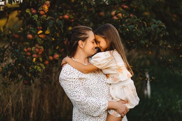 Mãe e filha estão abraçando com os olhos fechados