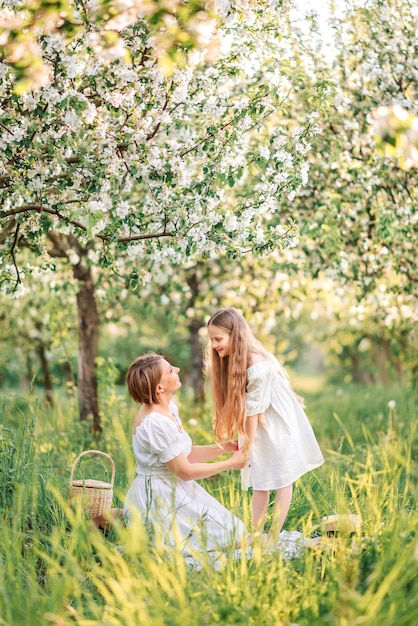 Foto mãe e filha estão caminhando no jardim de primavera