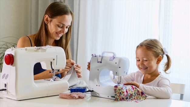 Mãe e filha estão costurando juntos uma máquina