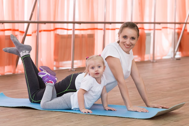 Mãe e filha estão envolvidas em ginástica.