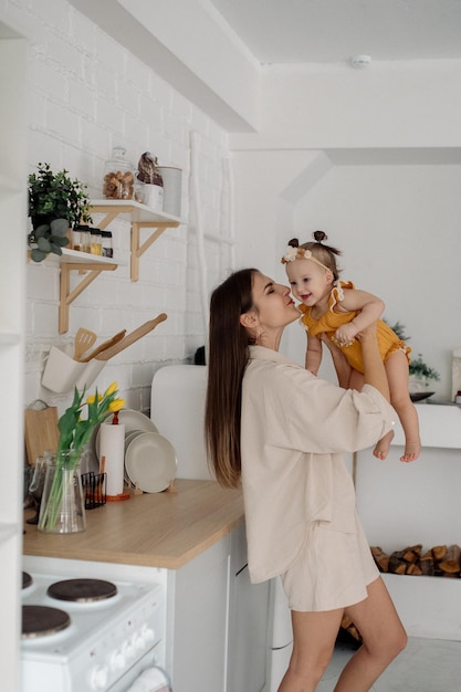 Foto mãe e filha estão se abraçando na cozinha vida familiar em casa