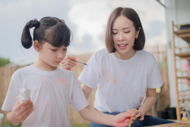 Mãe e filha estudando arte desenham uma boneca