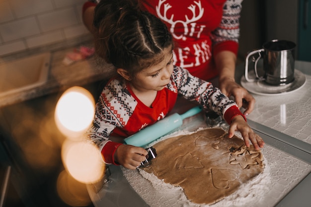 Mãe e filha fazem biscoitos de natal