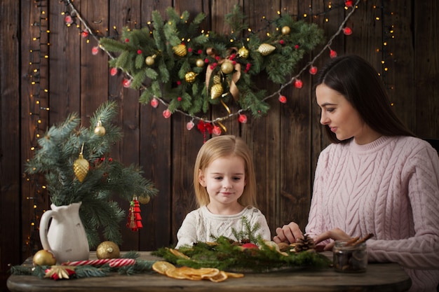 Mãe e filha fazem guirlanda de natal