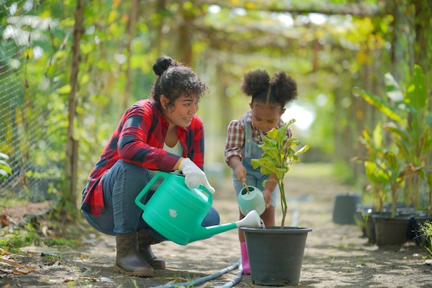 Mãe e filha fazendo atividades ao ar livre no jardim família diversa fim de semana de maternidade feliz junto com o conceito de dia das mães criança