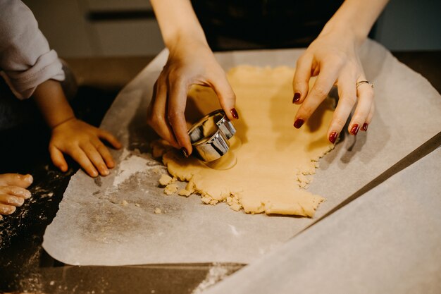 Mãe e filha fazendo biscoitos com cortadores de metal