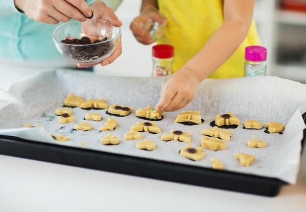 Foto mãe e filha fazendo biscoitos em casa