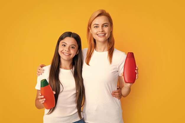 Mãe e filha fazendo cuidados capilares matinais Mãe e filho sorridentes no show clean mockup shampoo condicionador ou garrafas de lavagem de rosto Produtos dermatológicos para crianças e adultos