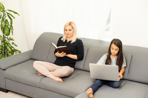 mãe e filha fazendo lição de casa com um tablet