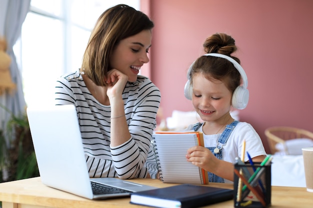 Mãe e filha fazendo lição de casa online. Educação online de ensino à distância.