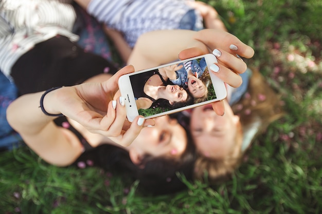 Mãe e filha fazendo selfie em smartphone