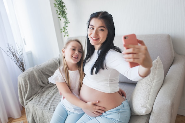 Mãe e filha fazendo selfie juntos.