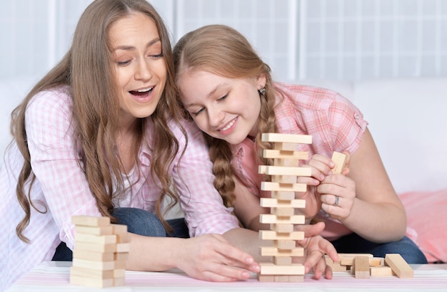 Mãe e filha felizes na mesa jogando jogo de tabuleiro