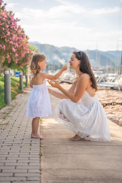 Mãe e filha felizes se divertindo em iates de luxo no fundo da marina Conceito de férias de estilo de vida de viagem familiar