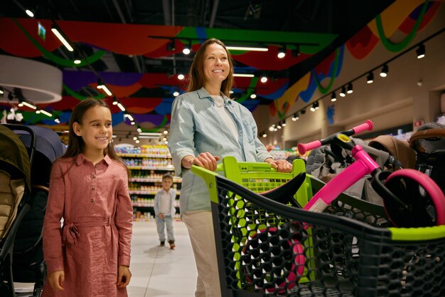 Mãe e filha grávidas positivas a fazer compras na loja de brinquedos.