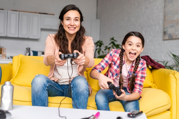 Foto mãe e filha jogando videogame