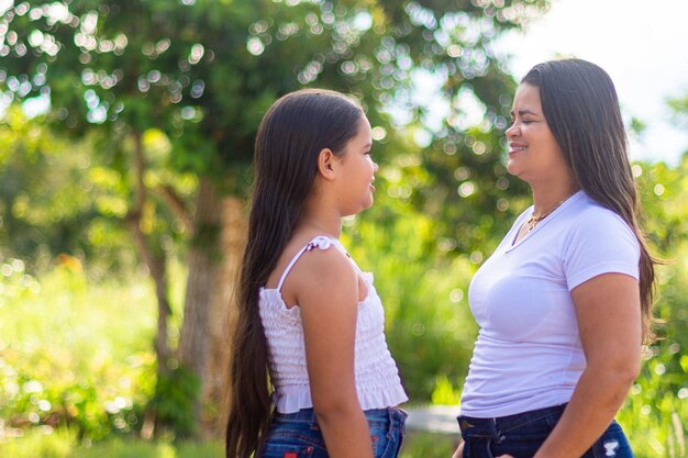 Foto mãe e filha latinas no brasil aproveitando o espaço verde ao ar livre