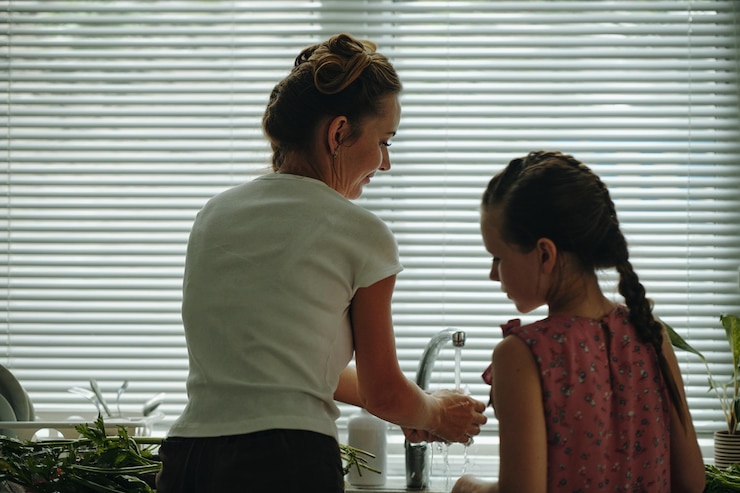 Foto mãe e filha lavando legumes