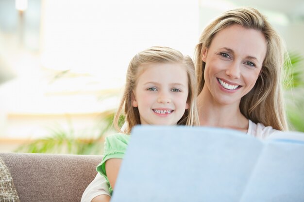 Mãe e filha lendo no sofá