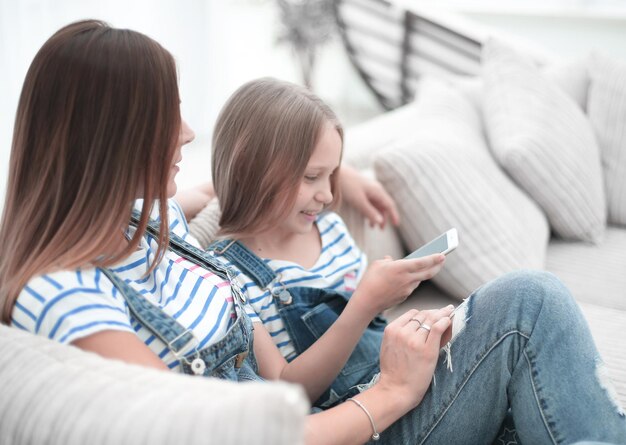 Mãe e filha lendo sms no smartphone