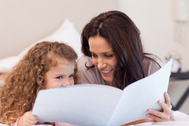 Mãe e filha lendo um livro juntos