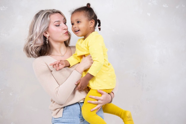 Mãe e filha multiétnicas brincam em casa