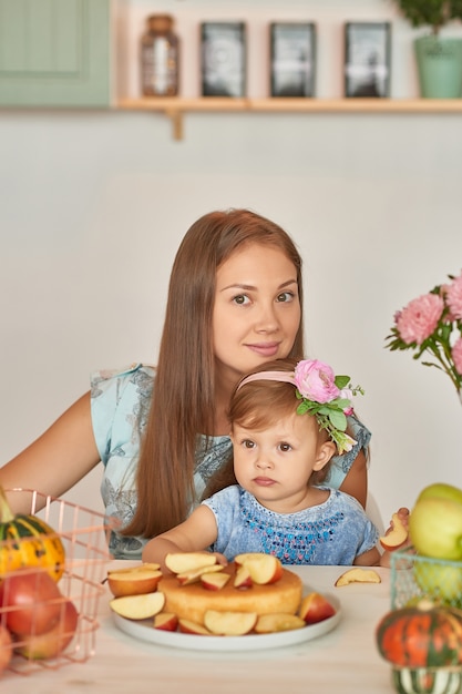 Mãe e filha na cozinha com decorações de ação de Graças