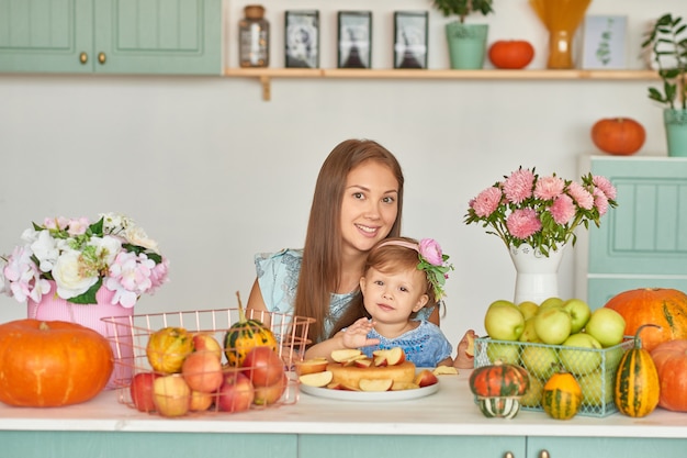 Mãe e filha na cozinha com decorações de ação de Graças