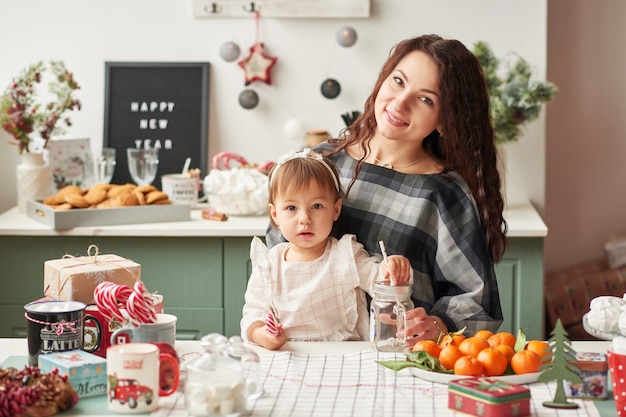 mãe e filha na cozinha decorada para o ano novo e natal