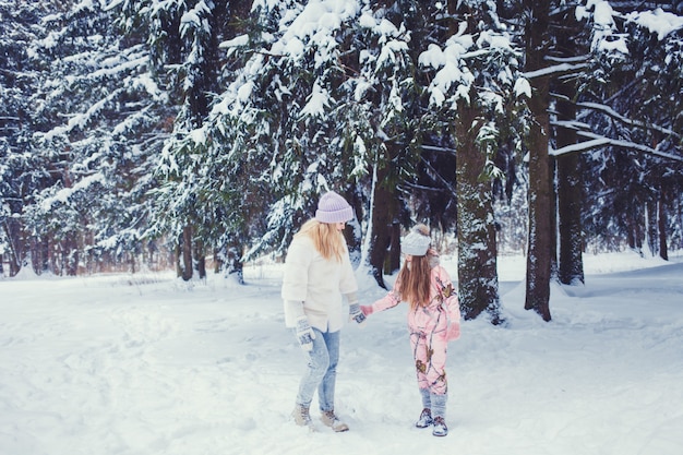 Mãe e filha na floresta de inverno