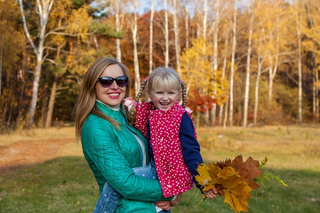 Mãe e filha na floresta de outono