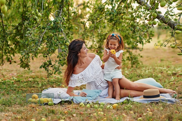 Mãe e filha no jardim de maçã