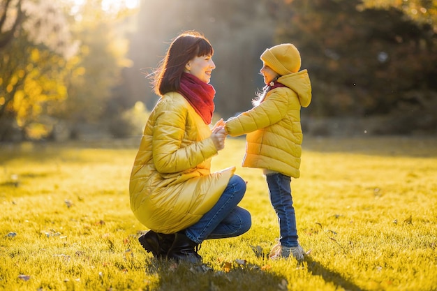 Mãe e filha no parque outono amarelo.