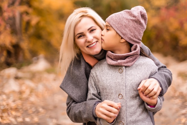 Mãe e filha no parque outono amarelo.