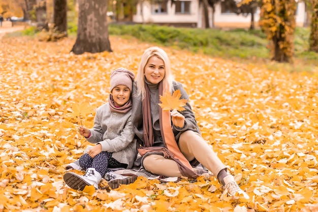 Mãe e filha no parque outono amarelo.