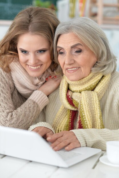 Foto mãe e filha passando um tempo juntas, usando laptop