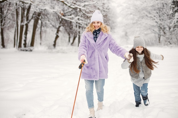 Mãe e filha passeando com cachorro no inverno