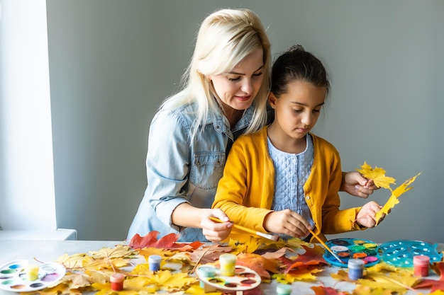 mãe e filha pintam folhas de outono