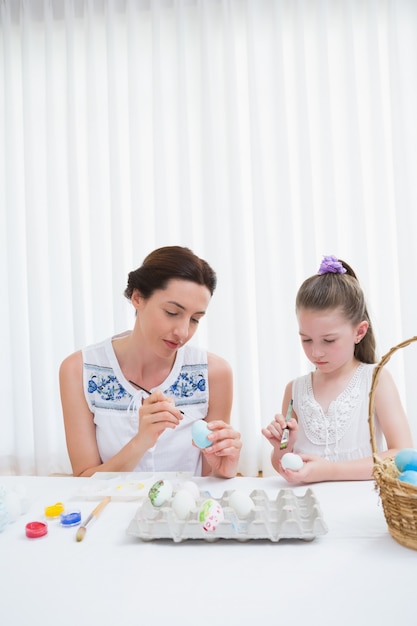 Mãe e filha, pintando ovos de páscoa