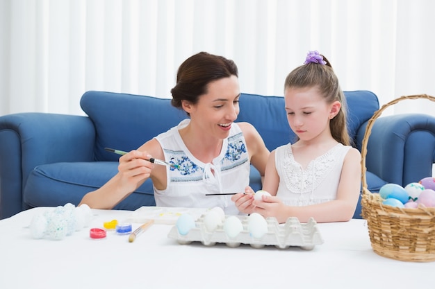 Mãe e filha, pintando ovos de páscoa