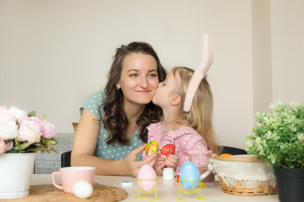 Mãe e filha pintando ovos para a Páscoa