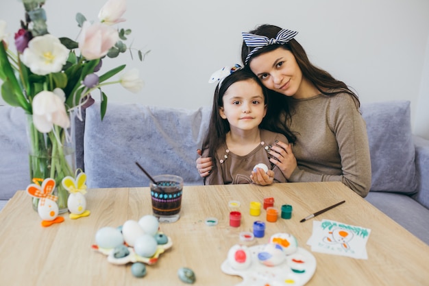 Mãe e filha pintar ovos de Páscoa.