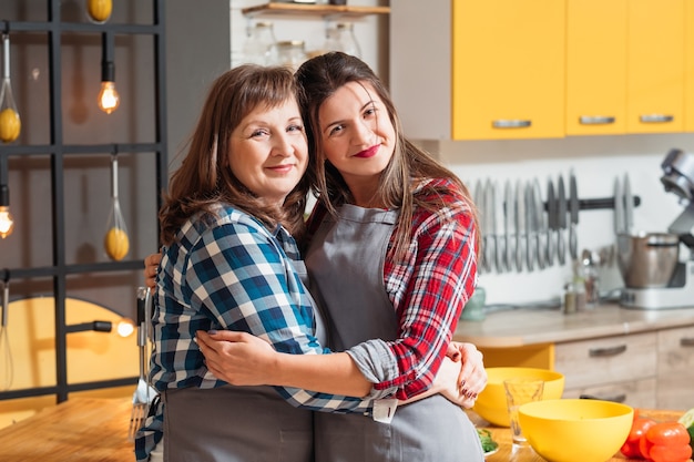 Mãe e filha posando na cozinha da família